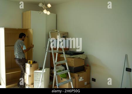 MAILAND, ITALIEN - 30. Sep 2021: Ein Mann hält und bewegt Holzregale während eines Wohnumzugs in Mailand, Italien Stockfoto