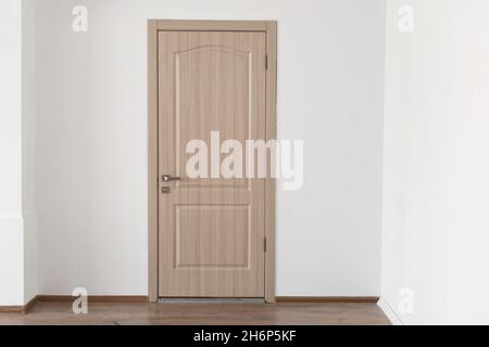 Geschlossene Holztür an der Wand, neue Wohnung Stockfoto