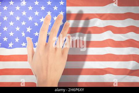 Eine Frauenhand auf dem Hintergrund der Nationalflagge Amerikas. Eine Geste mit erhobener Hand vor dem Hintergrund der US-Flagge Stockfoto