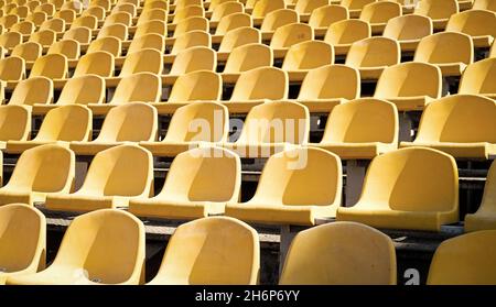 Gelbe Tribünen. Sitze der Tribüne auf Sportstadion. Leere Außenarena. Konzept der Fans. Stühle für Publikum. Kulturelle Umwelt Konzept. Farbe und Stockfoto