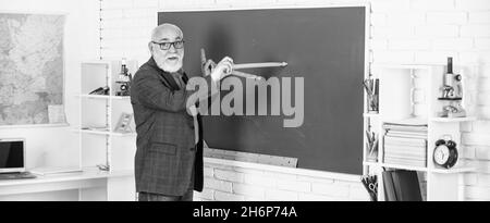 Wiederholen Sie nach mir. In Richtung Wissen. Studieren Sie Mathematik, um gute Ergebnisse zu erhalten. Senior man Lehrer verwenden Kompass-Werkzeug. Bärtiger Tutor Mann zeichnen mit Kompass auf Stockfoto
