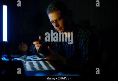 Männlicher Numismatiker fotografiert Sammlung von Münzen zum Verkauf. Stockfoto