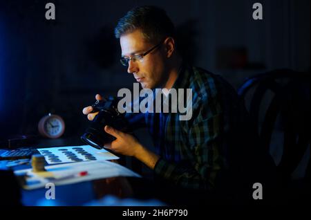 Männlicher Numismatiker fotografiert Sammlung von Münzen zum Verkauf. Stockfoto