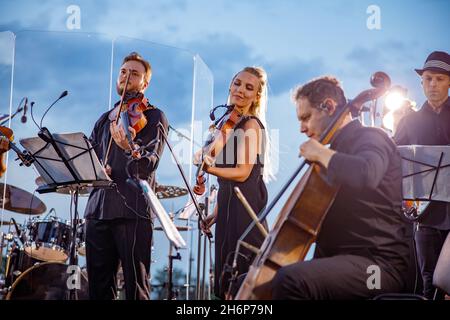Musikalisches Ensemble mit Orchesterkonzert gegen den blauen Himmel Stockfoto