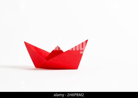 Origami rotes Papierboot auf weißem Hintergrund. Stockfoto