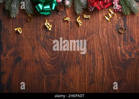 Weihnachtstanne Äste, Weihnachtskugeln, Geschenkbox, hölzerne Schneeflocken und Sterne auf altem hölzernen Hintergrund für Ihre Weihnachtsgrüße. Draufsicht mit CO Stockfoto