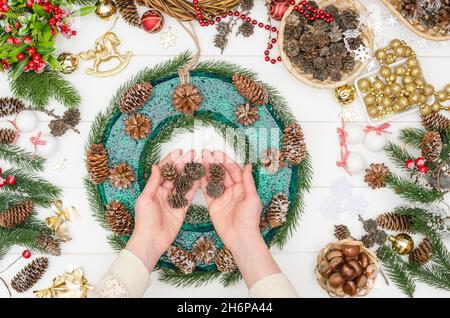 Schritt für Schritt einen großen Weihnachtskranz machen, Schritt 7 - kleine Lärchenzapfen nehmen Stockfoto