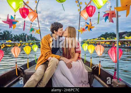 Ein glückliches Paar von Reisenden fährt auf einem Nationalboot auf dem Hintergrund der alten Stadt Hoi in Vietnam. Vietnam öffnet sich nach der Quarantäne wieder für Touristen Stockfoto