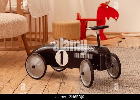 Schwarzes Retro-Kinderauto im Kinderzimmer Stockfoto