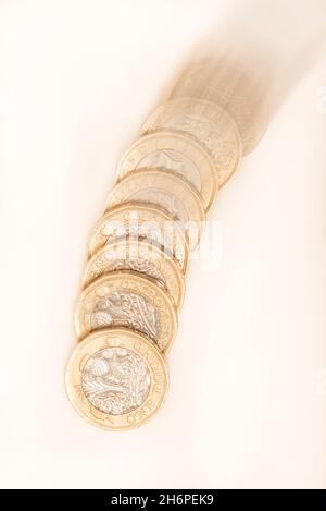 Geld: Nahaufnahme von 1-Pfund-Münzen, die scheinbar fallen/fallen oder steigen, wenn das Bild umgekehrt ist. Pfund Sterling Währung auf weißem Hintergrund. £1 Stockfoto