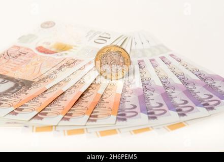 Geld: Ein und zwei-Pfund-Münzen saßen auf zehn und zwanzig-Pfund-Scheinen. £1 £10 £20 Pfund Sterling Währung. Nahaufnahme, Hintergrund. Stockfoto