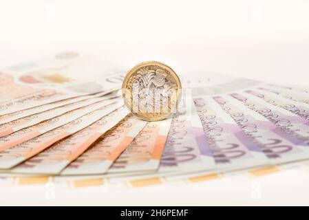 Geld: Ein und zwei-Pfund-Münzen saßen auf zehn und zwanzig-Pfund-Scheinen. £1 £10 £20 Pfund Sterling Währung. Nahaufnahme, Hintergrund. Stockfoto