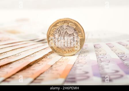 Geld: Ein und zwei-Pfund-Münzen saßen auf zehn und zwanzig-Pfund-Scheinen. £1 £10 £20 Pfund Sterling Währung. Nahaufnahme, Hintergrund. Stockfoto