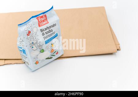 INVERIGO, ITALIEN - 16. Nov 2021: Chemische Verbindung aus Natriumbicarbonat in einer Plastiktüte und braunes Papier auf einer weißen Tischplatte mit Platz für Text Stockfoto