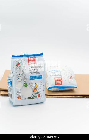 INVERIGO, ITALIEN - 16. Nov 2021: Chemische Verbindung aus Natriumbicarbonat in einer Plastiktüte und braunes Papier auf einer weißen Tischplatte mit Platz für Text Stockfoto