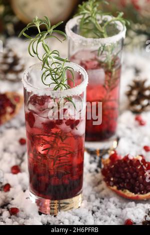 Glas mit Granatapfel Margarita mit kandierten Preiselbeeren, Rosmarin. Perfekter Cocktail für eine Weihnachtsfeier Stockfoto