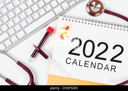 Tischkalender 2022 mit Medikamenten und medizinischen Stethoskopen. 2022 Medizinische Konzepte. Stockfoto