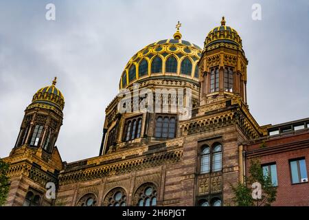 Großartige Nahaufnahme der Hauptkuppel der Neuen Synagoge in Berlin mit ihren vergoldeten Rippen, flankiert von zwei kleineren, pavillonartigen Kuppeln auf den beiden Seitenflügeln... Stockfoto