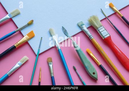 Verschiedene Pinsel und weiße Leinwand. Bildung, Schule und Kunstkonzept. Freier Speicherplatz für Text Stockfoto
