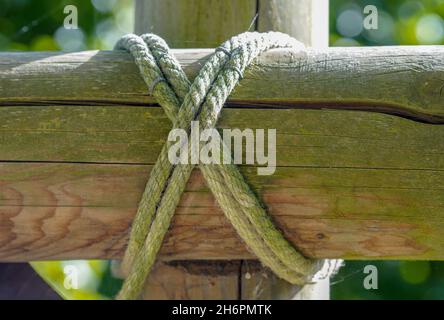 Nahaufnahme eines Seils, das über einem Holzbalken gebunden ist Stockfoto