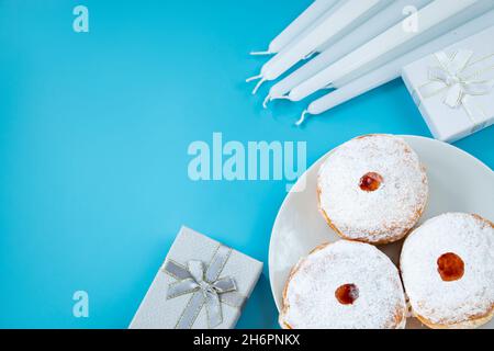 Symbole des jüdischen religiösen Feiertages Chanukka. Traditionelle Dessert Donuts sufganiyot auf blauem Hintergrund. Speicherplatz kopieren. Stockfoto