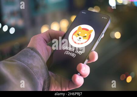 SHIBA INU Kryptowährungssymbol, Logo. Geschäfts- und Finanzkonzept. Hand mit Smartphone, Bildschirm mit Krypto-Symbol Nahaufnahme Stockfoto