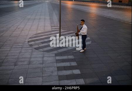 Der Saxophonist spielt abends auf der Straße Stockfoto