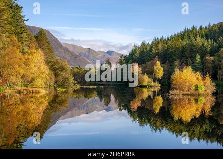 Herbstreflexionen zu den entfernten Mamor Hills, Lochan Trail, Glencoe Stockfoto