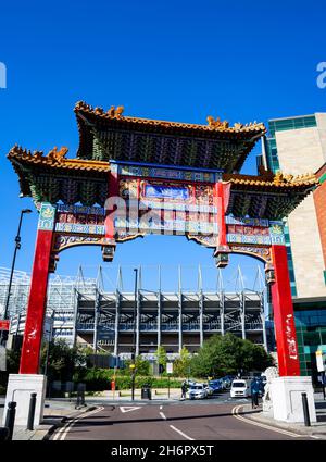 Chinatown Gate in Newcastle upon Tyne, mit St. James' Park (dem Stadion des FC Newcastle United) im Hintergrund Stockfoto