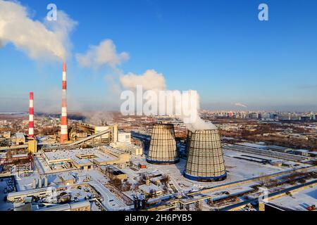 Blick auf die Rohre des Heizwerks von oben an klaren Wintertagen. Rauch kommt aus Schornsteinen. Heizen Stadt mit Erdgas im Winter. Beginn der Heizperiode. Hintergrund Stockfoto