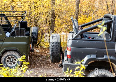 Zwei überdeckbare geländewagen mit Geländewagen im sowjetischen geländewagen auf unbefestigter Schotterstraße im Sommer bei Sonnenuntergang in der Morgensonne. Off Road Auto Berg Safari Abenteuer Stockfoto