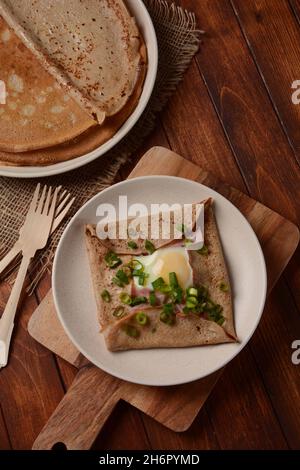 Bretonische Galette, Galette sarrasin, Buchweizenkrepe, mit Spiegelei, Käse, Schinken. Französische bretonische Küche. Stockfoto