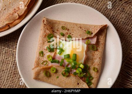 Bretonische Galette, Galette sarrasin, Buchweizenkrepe, mit Spiegelei, Käse, Schinken. Französische bretonische Küche. Stockfoto