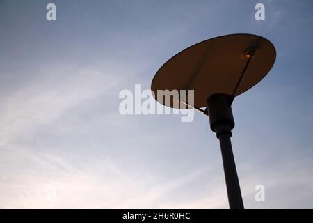 Die Design-Lampe und der leere blaue Himmel auf einer Straße Stockfoto