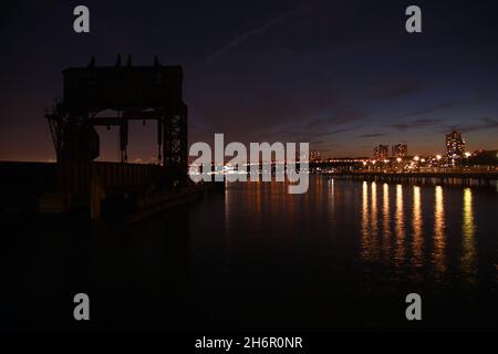 Eine Nachtaufnahme über den Fluss auf der 69th Street Transfer Bridge am Hudson River in New York City Stockfoto