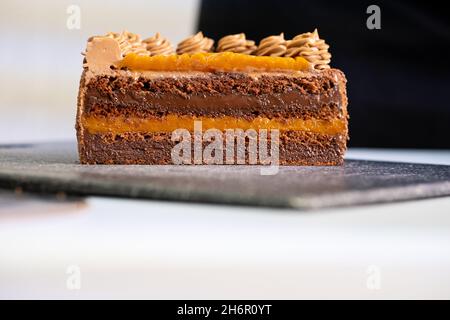 Leckeres Stück Kuchen auf schwarzem Teller. Stockfoto