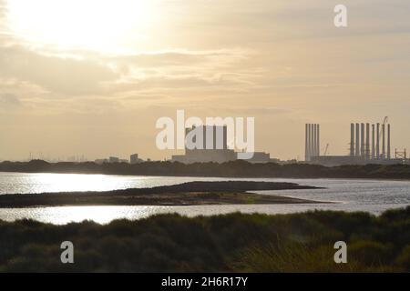 Atemberaubende Farbdarstellung mit Blick über Tees Bay auf das Kraftwerk EDF Hartlepool und die Windturbinen-Pole am benachbarten Able Seaton Port. Stockfoto