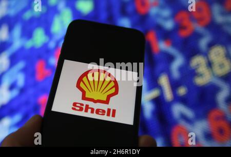Viersen, Deutschland - Juni 6. 2021: Nahaufnahme des Handybildschirms mit Logo-Schriftzug des königlichen holländischen Shell-Öls, Hintergrund der Börsenchart Stockfoto