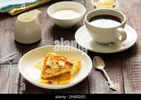 Frühstück mit Käsekuchen, Kaffee und Tee. Käsekuchen von einer ungewöhnlichen dreieckigen Form. Stockfoto