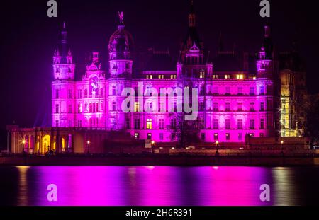 Schwerin, Deutschland. November 2021. Das Schweriner Schloss wird am Weltvorreifetag mit violettem Licht beleuchtet. Am 17. November erinnert uns der Welttag der Frühgeborenen an die großen Herausforderungen, die Familien mit früh geborenen Babys bewältigen müssen. Quelle: Jens Büttner/dpa-Zentralbild/dpa/Alamy Live News Stockfoto