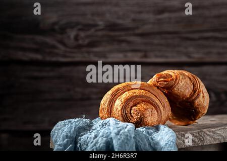 Frisch gebackene, duftende Croissants auf einem Holzhintergrund Stockfoto