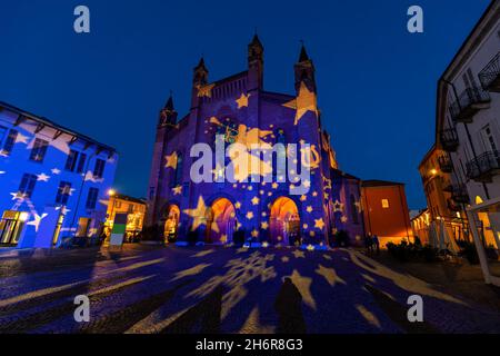 Die Kathedrale von San Lorenzo, die für die Weihnachtsfeiertage am Abend auf dem gepflasterten Platz in der Altstadt von Alba, Piemont, Norditalien, beleuchtet wird. Stockfoto