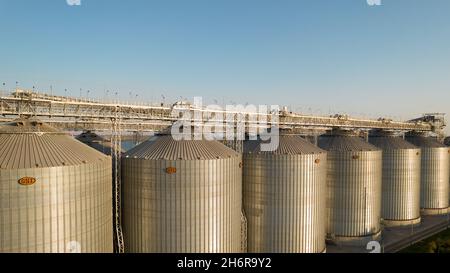 Odessa, Ukraine - Аugust 14, 2021: Getreideterminals des modernen Handelshafens. Silos zur Lagerung von Getreide in Strahlen untergehenden Sonnenlichtes, Draufsicht von Quadco Stockfoto