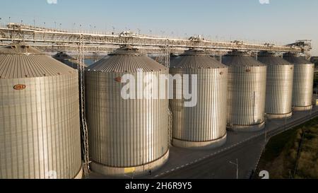 Odessa, Ukraine - Аugust 14, 2021: Getreideterminals des modernen Handelshafens. Silos zur Lagerung von Getreide in Strahlen untergehenden Sonnenlichtes, Draufsicht von Quadco Stockfoto