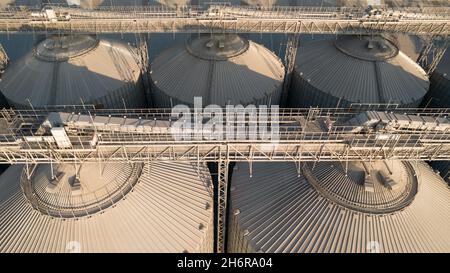 Odessa, Ukraine - Аugust 14, 2021: Getreideterminals des modernen Handelshafens. Silos zur Lagerung von Getreide in Strahlen untergehenden Sonnenlichtes, Draufsicht von Quadco Stockfoto