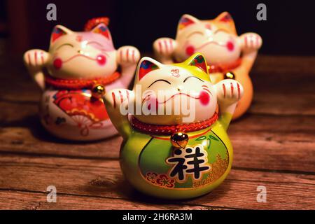 Japanische winkende Katzen (Maneki neko) aus Porzellan. Sie sind traditionelle Glückssymbole. Stockfoto