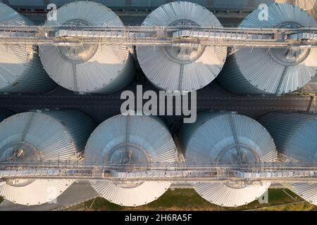 Odessa, Ukraine - Аugust 14, 2021: Getreideterminals des modernen Handelshafens. Silos zur Lagerung von Getreide in Strahlen untergehenden Sonnenlichtes, Draufsicht von Quadco Stockfoto