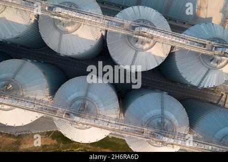 Odessa, Ukraine - Аugust 14, 2021: Getreideterminals des modernen Handelshafens. Silos zur Lagerung von Getreide in Strahlen untergehenden Sonnenlichtes, Draufsicht von Quadco Stockfoto