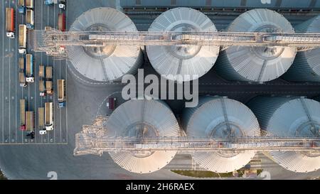 Odessa, Ukraine - Аugust 14, 2021: Getreideterminals des modernen Handelshafens. Silos zur Lagerung von Getreide in Strahlen untergehenden Sonnenlichtes, Draufsicht von Quadco Stockfoto