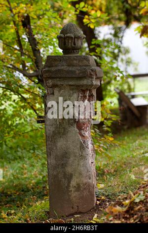 Laubsäule Vase auf Säule aus roten Ziegeln Garten mit hohen Pappelbäumen und einer Marmorvase auf einer Terrakotta-Säule Stockfoto